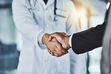 doctor and business man firmly shaking hands