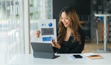woman showing paper graph on zoom meeting